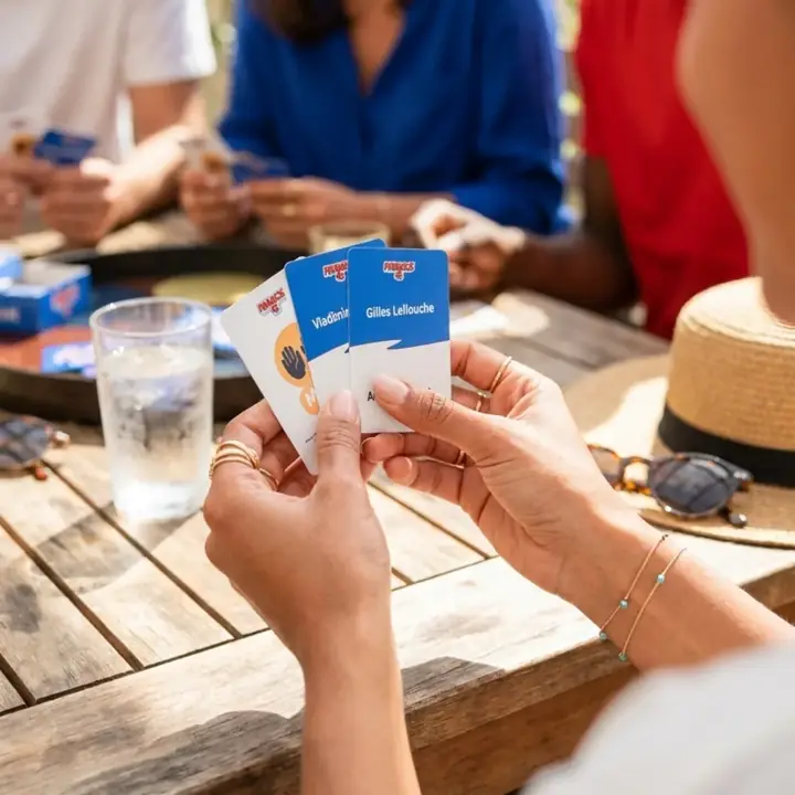 Trois cartes Francis 4L en main, autour d'une table en terrasse