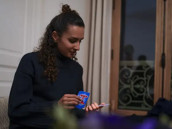 Une joueuse lit sa carte Francis 4L, le soir, à la maison